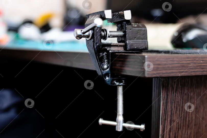 Скачать Черные металлические тиски на краю деревянного стола фотосток Ozero