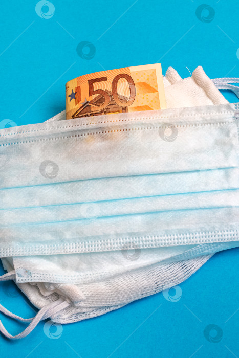 Скачать Медицинские маски и деньги на синем фоне, ценности во время эпидемии фотосток Ozero