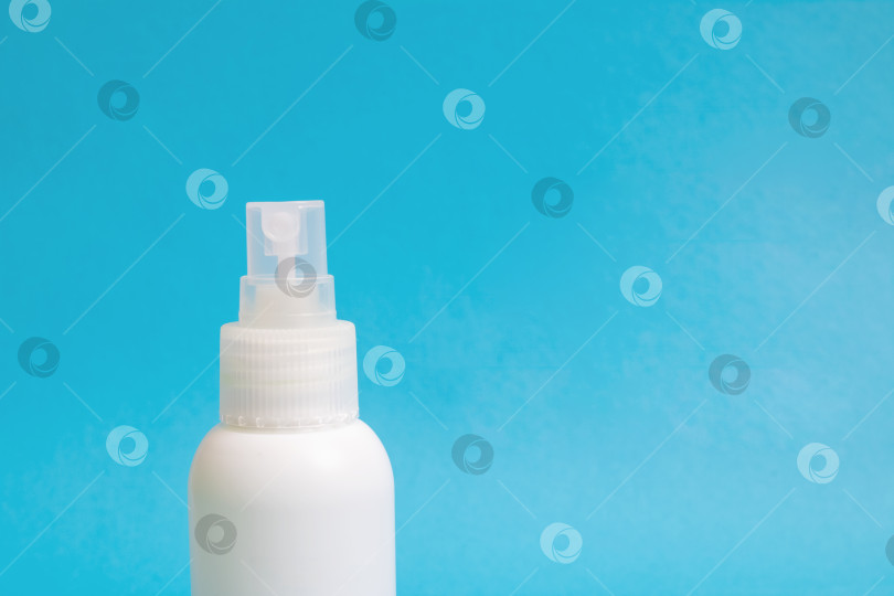 Скачать Белая пластиковая бутылка с дезинфицирующим средством на синем фоне фотосток Ozero
