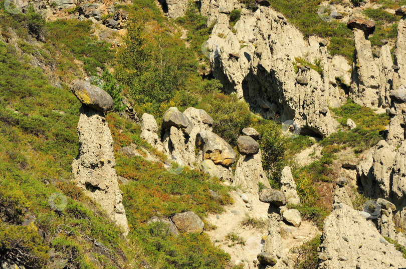 Скачать Необычные каменные образования из глины и песчаника на склоне высокой горы в ясный летний день. фотосток Ozero