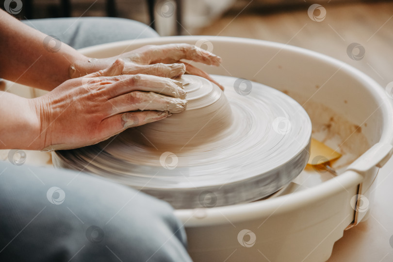 Скачать Руки керамиста создают глиняную посуду на гончарном круге фотосток Ozero