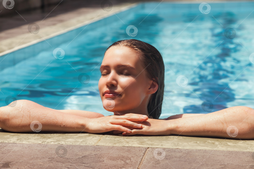 Скачать Молодая стройная женщина в купальнике отдыхает у бассейна фотосток Ozero