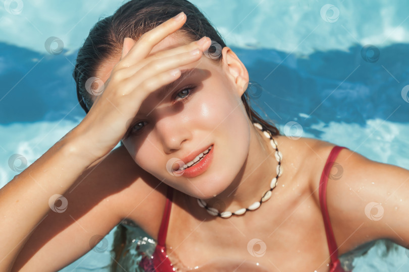 Скачать Молодая стройная женщина в купальнике отдыхает у бассейна фотосток Ozero