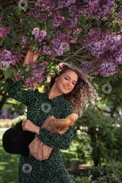 Скачать Симпатичная молодая женщина во французском стиле с багетами в руках фотосток Ozero