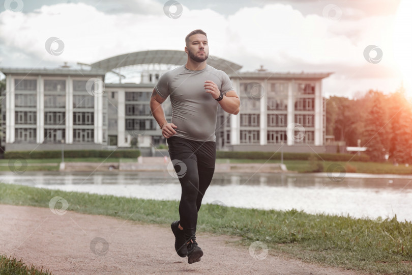 Скачать Мужчина спортсмен бегун, бегущий в парке, тренирующийся и осуществляющий физические упражнения фотосток Ozero