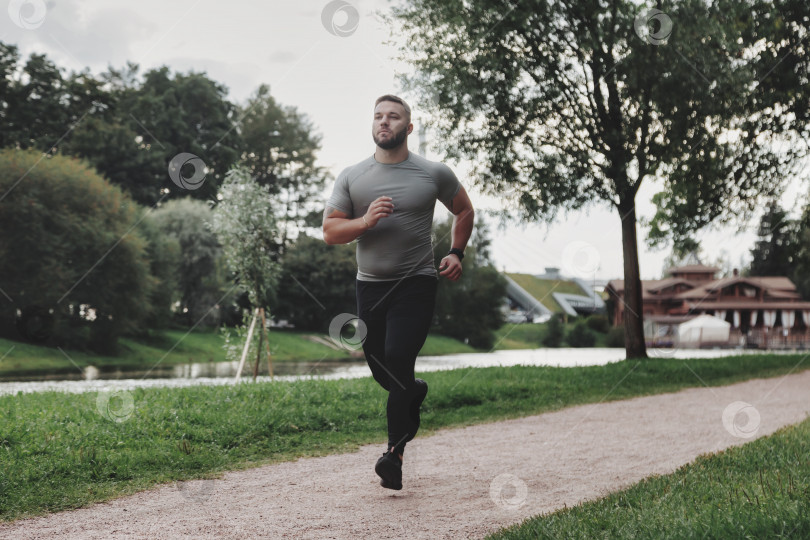 Скачать Мужчина спортсмен бегун, бегущий в парке, тренирующийся и осуществляющий физические упражнения фотосток Ozero