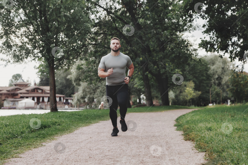 Скачать Мужчина спортсмен бегун, бегущий в парке, тренирующийся и осуществляющий физические упражнения фотосток Ozero