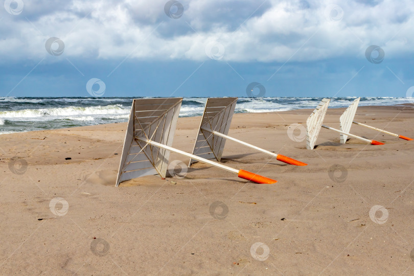 Скачать Пляжные зонтики лежат на песке фотосток Ozero