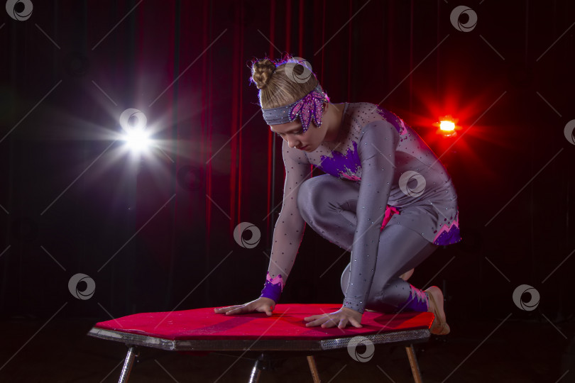 Скачать Девушка-цирковая акробатка, гимнастка на сцене на темном фоне. фотосток Ozero