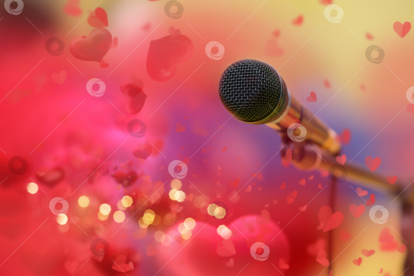 Скачать Сценический золотой микрофон на фоне красных сердечек валентинки и золотого боке. фотосток Ozero
