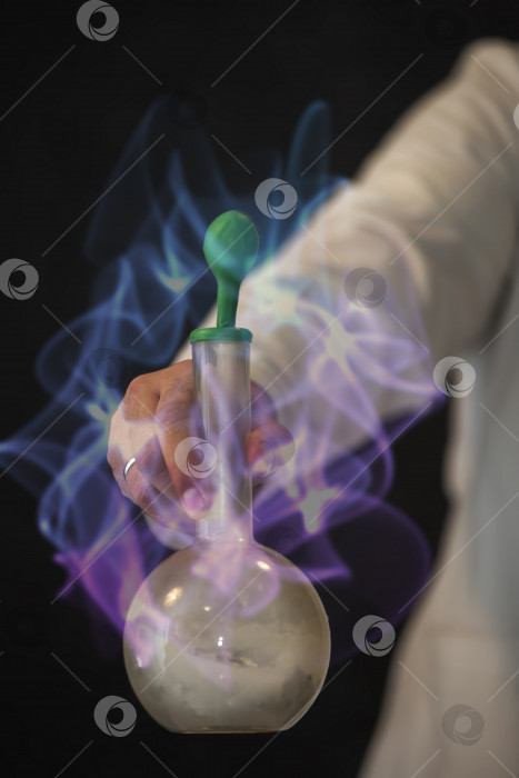 Скачать Рука ученого держит колбу с химическим веществом на фоне волшебного свечения. фотосток Ozero