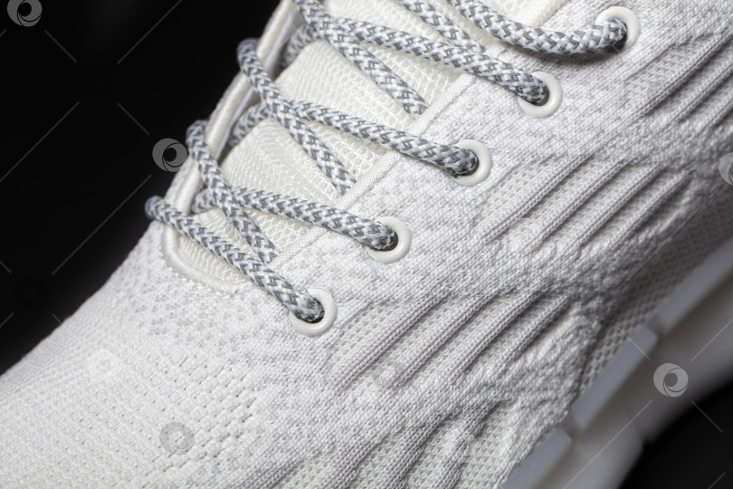 Скачать Часть кроссовок из белой ткани на темном фоне. фотосток Ozero