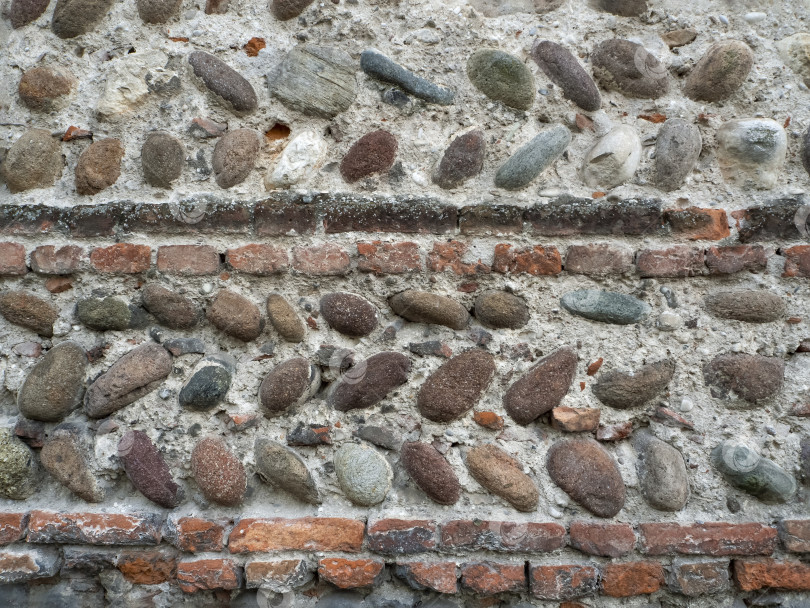 Скачать Исторический фон со старинной каменной стеной. Стена выложена булыжником и кирпичами, скрепленными цементом. Каменный фон крупным планом. фотосток Ozero