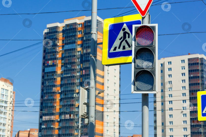 Скачать Красный запрещающий сигнал светофора на фоне высотных зданий фотосток Ozero