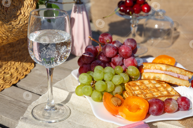 Скачать Натюрморт и фотография с едой. Тарелка с фруктами и стакан воды стоят на мешковине на деревянном полу фотосток Ozero