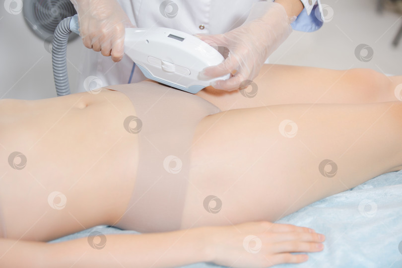 Скачать Крупный план девушки на косметологическом кресле во время процедуры лазерной эпиляции зоны бикинии фотосток Ozero