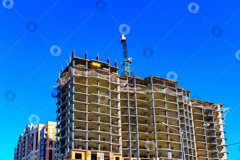 Скачать Новое строящееся высотное здание на фоне голубого неба. Концепция ипотечного кредитования и финансирования строительства. фотосток Ozero
