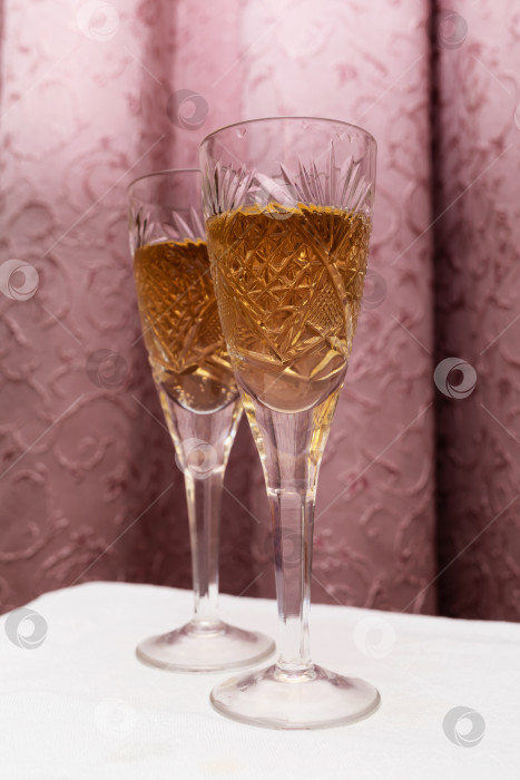 Скачать Два хрустальных бокала с шампанским на фоне занавески, концепция в стиле девяностых фотосток Ozero