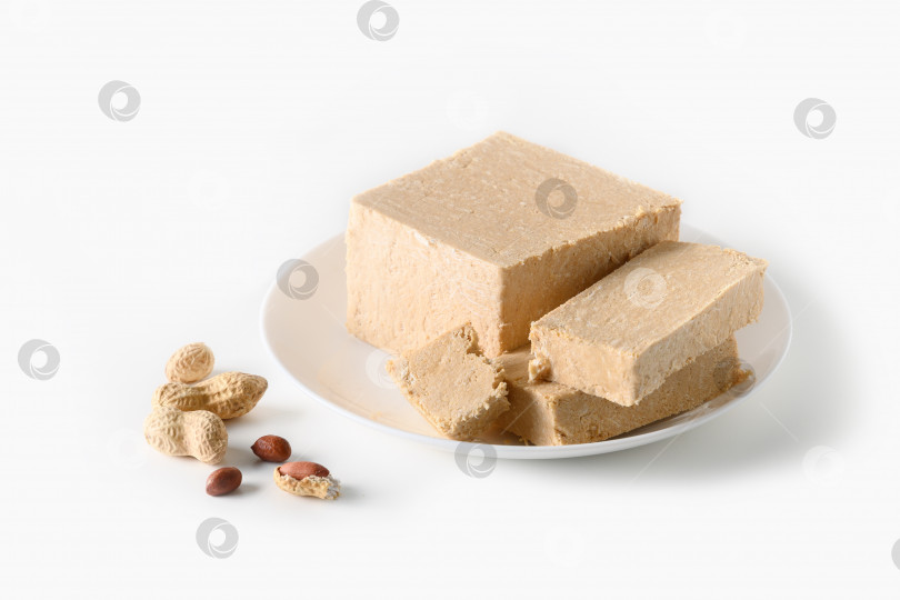 Скачать Восточный сладкий десерт - арахисовая халва в тарелке, выделенная на белом фоне. фотосток Ozero