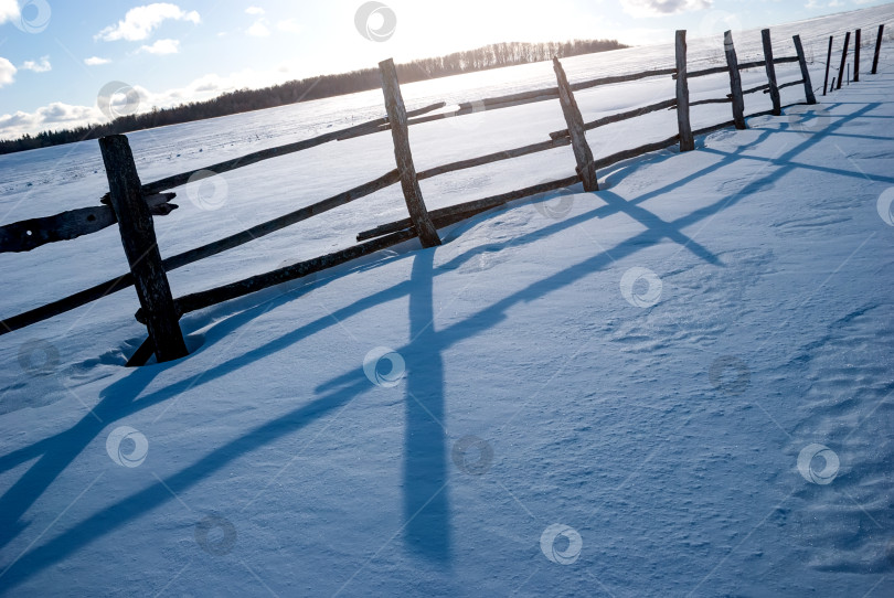 Скачать Зимний пейзаж. Забор в сугробах на фоне леса и солнца. фотосток Ozero