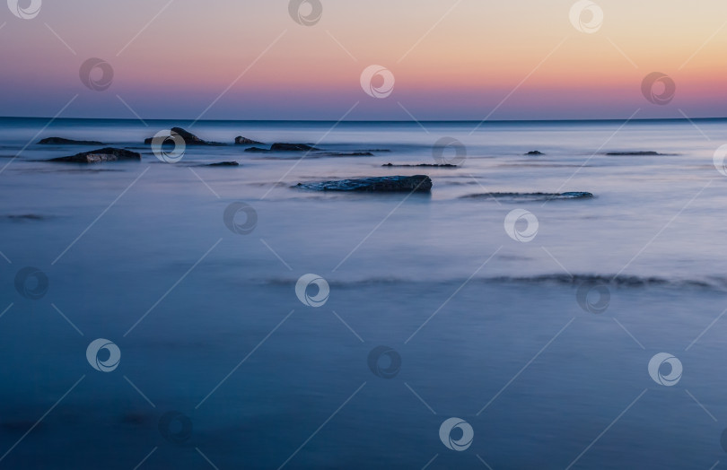 Скачать Морской пейзаж на закате. Море на длинной шторке с камнями и утесами. фотосток Ozero