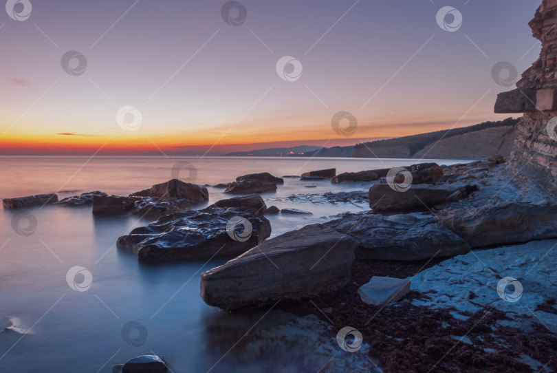 Скачать Морской пейзаж на закате. Море на длинной шторке с камнями и утесами. фотосток Ozero