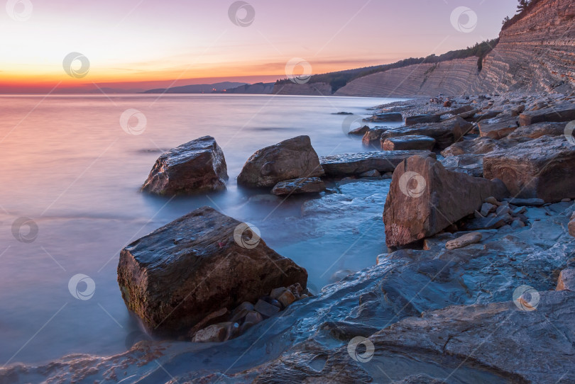 Скачать Морской пейзаж на закате. Море на длинной шторке с камнями и утесами. фотосток Ozero