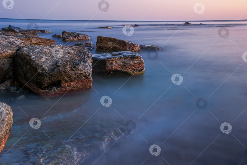 Скачать Морской пейзаж на закате. Море на длинной шторке с камнями и утесами. фотосток Ozero