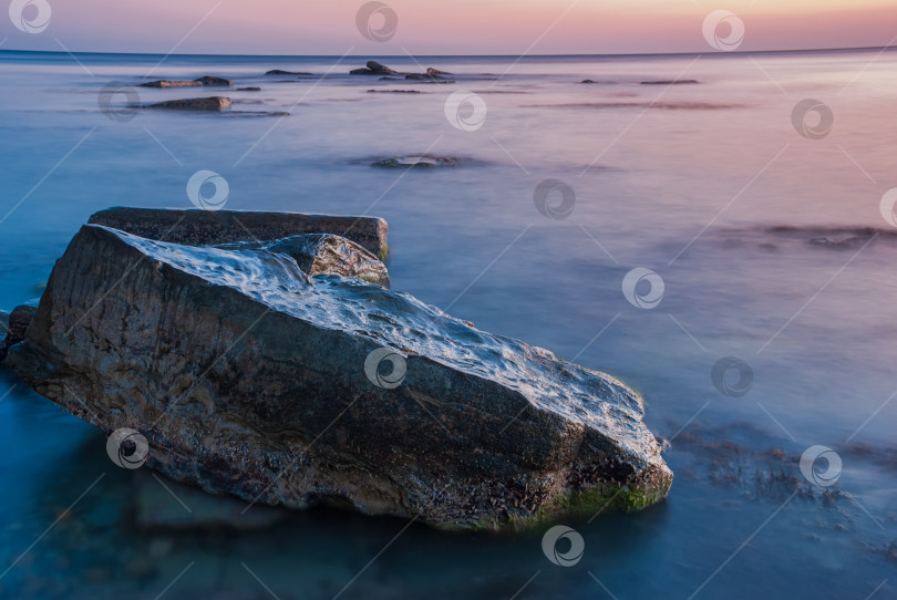 Скачать Морской пейзаж на закате. Море на длинной шторке с камнями и утесами. фотосток Ozero