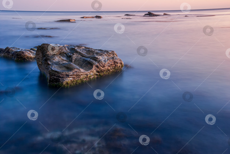 Скачать Морской пейзаж на закате. Море на длинной шторке с камнями и утесами. фотосток Ozero