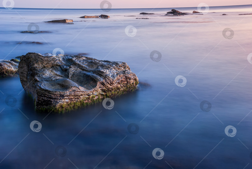 Скачать Морской пейзаж на закате. Море на длинной шторке с камнями и утесами. фотосток Ozero