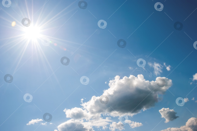 Скачать Куча белых облаков, солнце с длинными лучами и бликами на голубом небе. Небесный пейзаж фотосток Ozero