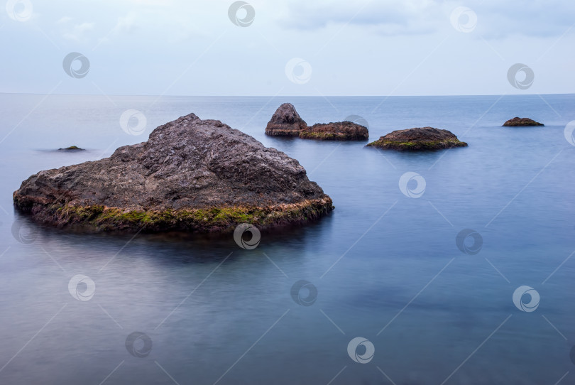 Скачать Утренний морской пейзаж. Морская вода при длительном воздействии, камни и утесы. Красивое небо с облаками. фотосток Ozero