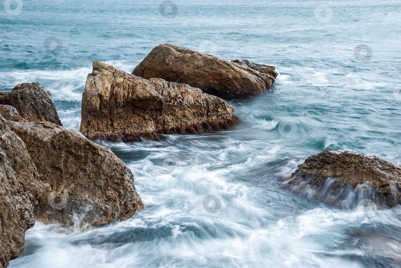 Скачать Морской пейзаж крымского побережья. Волны разбиваются красивыми брызгами о скалы. фотосток Ozero