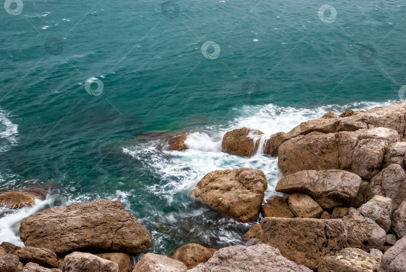 Скачать Морской пейзаж крымского побережья. Волны разбиваются красивыми брызгами о скалы. фотосток Ozero