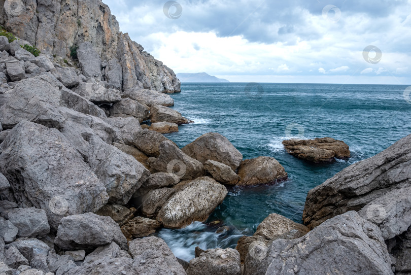 Скачать Морской пейзаж крымского побережья. Волны разбиваются красивыми брызгами о скалы. фотосток Ozero