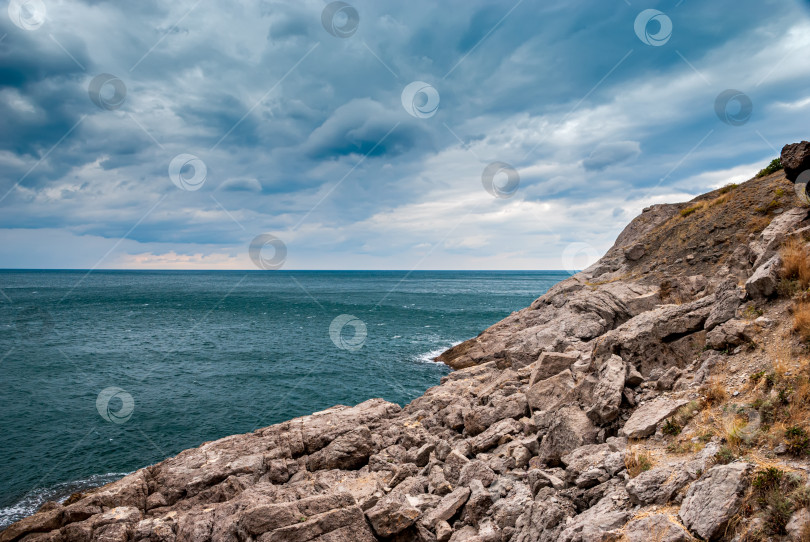 Скачать Морской пейзаж крымского побережья. Волны разбиваются красивыми брызгами о скалы. фотосток Ozero