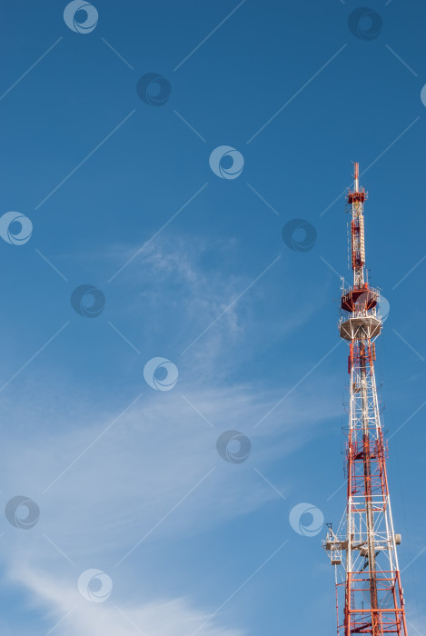 Скачать Телекоммуникационная башня из металла на фоне голубого неба с облаками. фотосток Ozero