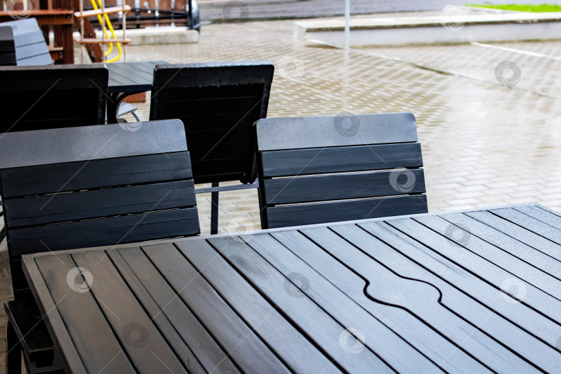 Скачать Уличный стол и стулья промокли под дождем фотосток Ozero