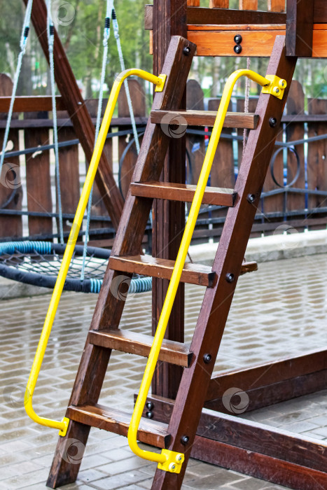 Скачать Деревянная лестница на детской площадке, мокрая под дождем фотосток Ozero