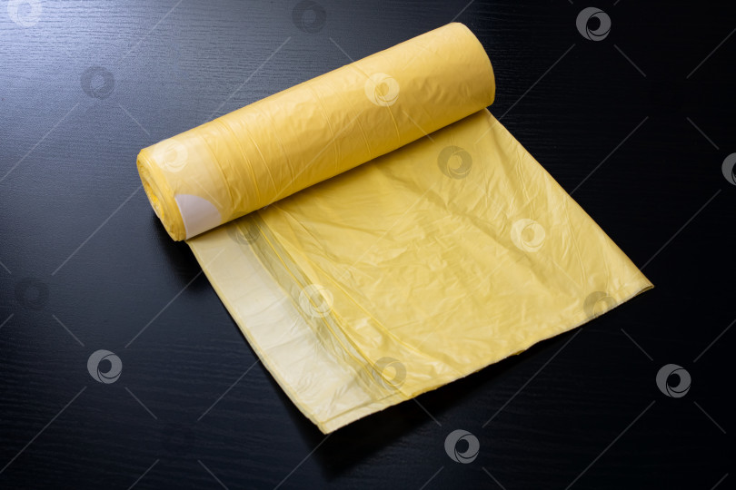 Скачать Желтые мешки для мусора на деревянном столе фотосток Ozero