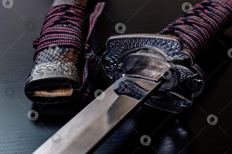 Скачать Самурайский меч на черном деревянном столе фотосток Ozero