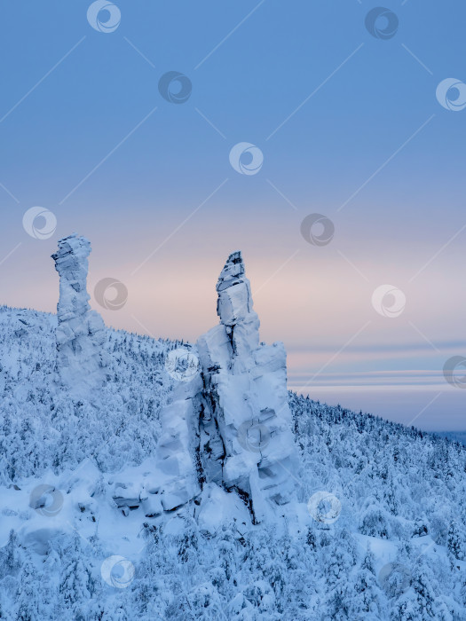 Скачать Столбы выветривания. Высокий каменный утес, покрытый снегом фотосток Ozero