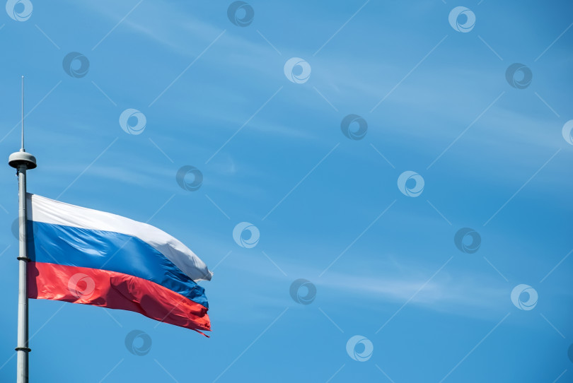 Скачать Российский флаг на фоне голубого неба. фотосток Ozero