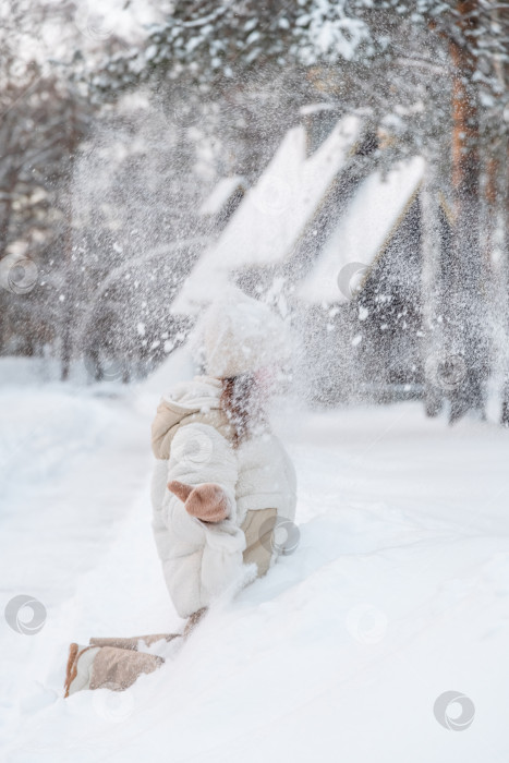 Скачать Девушка подбрасывает снег зимой. фотосток Ozero