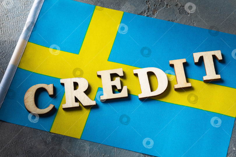 Скачать Текст из деревянных букв и флаг Швеции на абстрактном фоне, концепция на тему использования кредита в Швеции фотосток Ozero