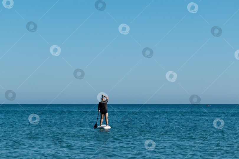 Скачать Белый мужчина на весельной доске в море фотосток Ozero