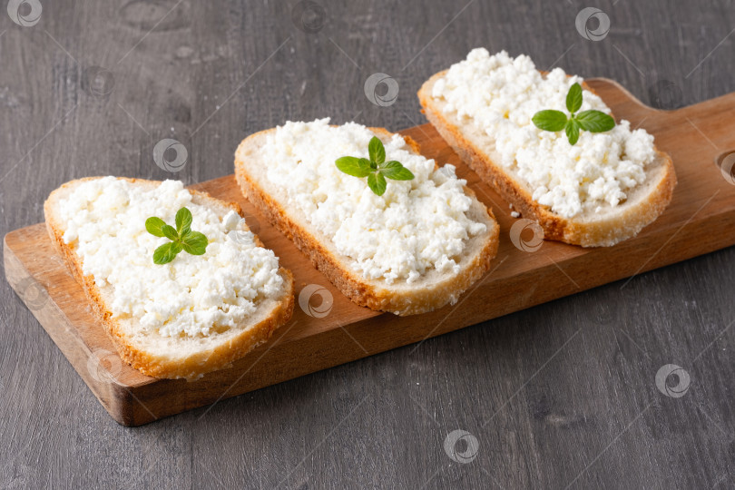 Скачать Хлеб с творожным сыром на деревянной доске фотосток Ozero