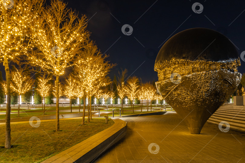 Скачать Иллюминация на Новый год и Рождество в золотом ночном свете в городском парке Краснодара или Галицком парке. Арт-объект, скульптура "Геолокация" или "Перевернутая капля". фотосток Ozero