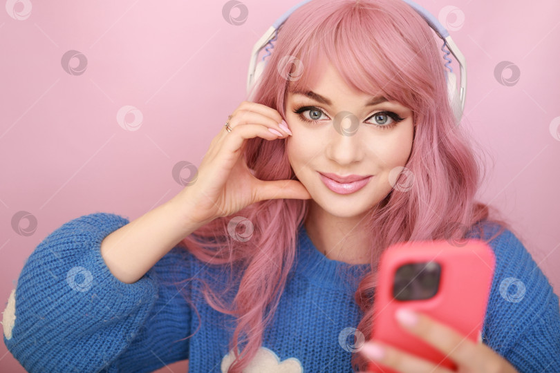 Скачать Портрет девушки с розовыми волосами с мобильником в руке и наушниками на голове. слушает музыку. разные эмоции.серия кадров фотосток Ozero
